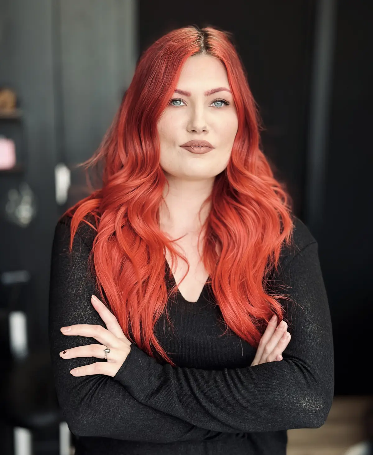 Timillia in her studio, arms crossed, long red hair